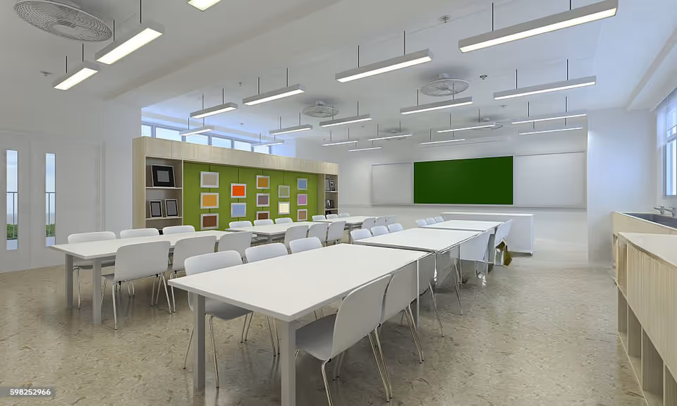 Bright, modern classroom-style facility with white tables and chairs facing a green board.