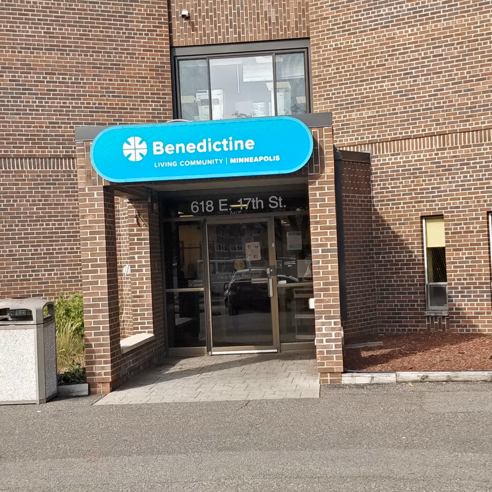 Brick building entrance with Benedictine Living Community Minneapolis sign above glass doors