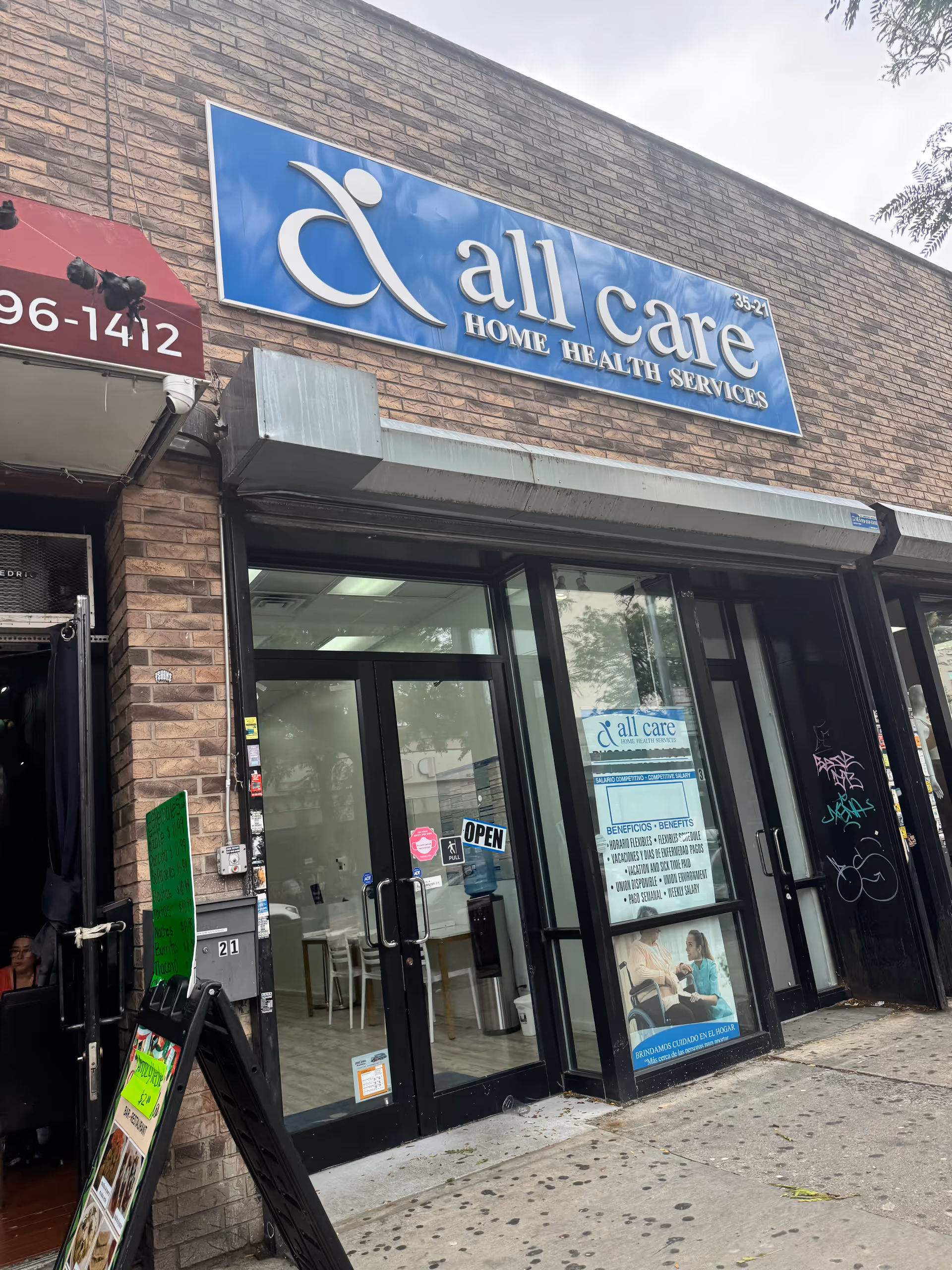 Front exterior of a brick building with a blue All Care Home Health Services sign.