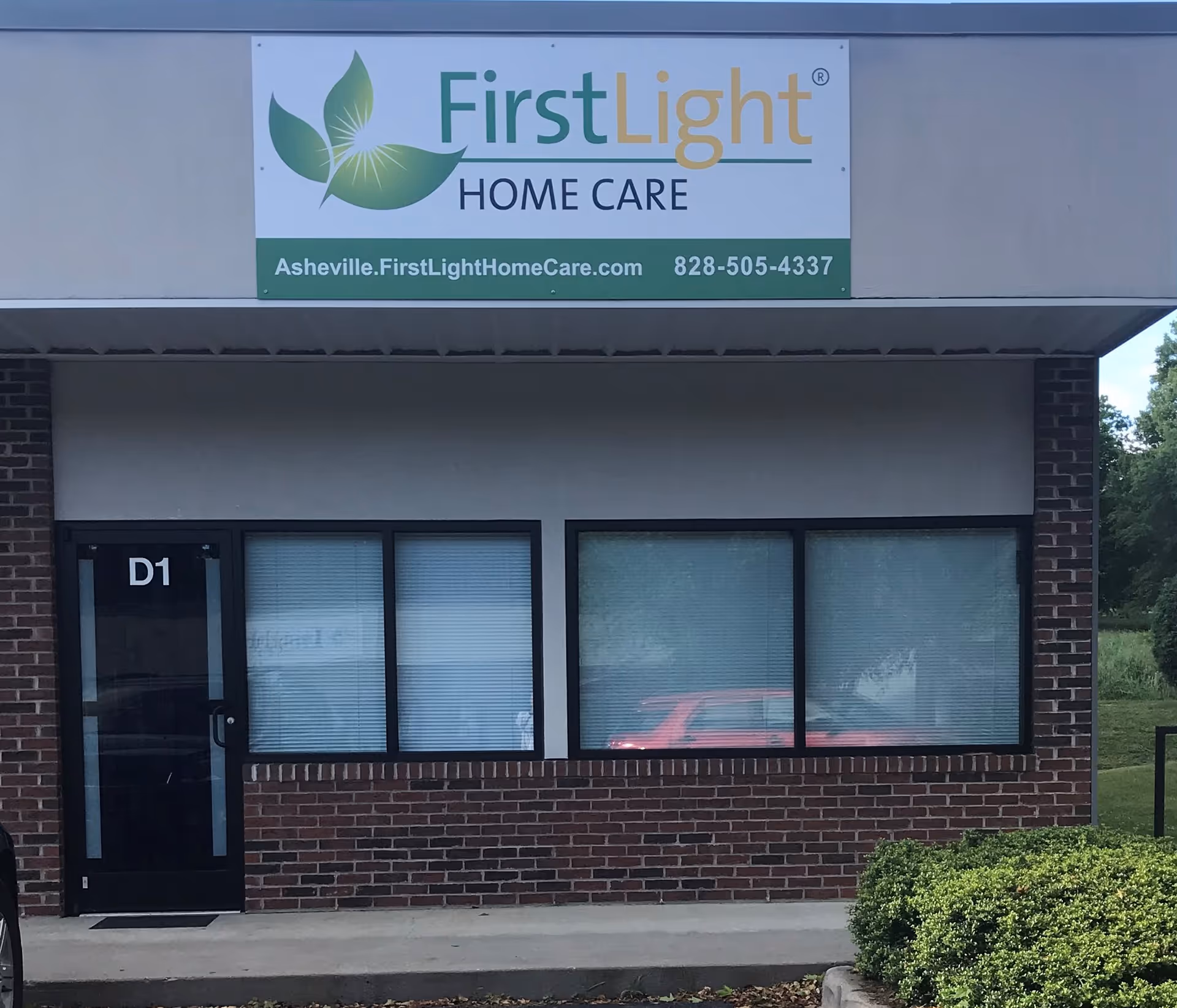 Front exterior of FirstLight Home Care Asheville building with a sign and three windows.