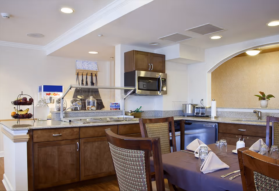 Communal kitchen and dining area with countertop, microwave, and a table set for meals.