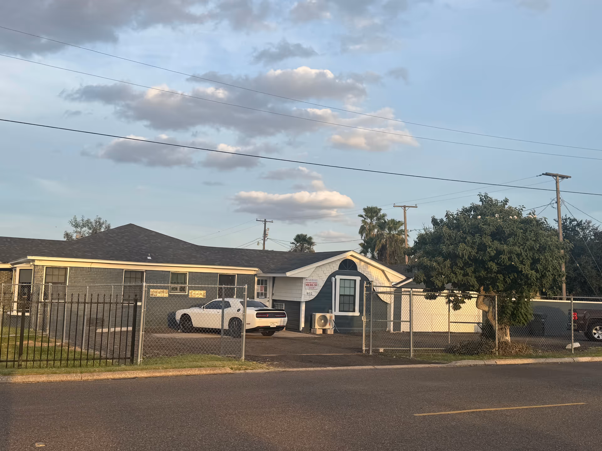Exterior view of Our Mission Primary Home Care facility behind a chain-link fence