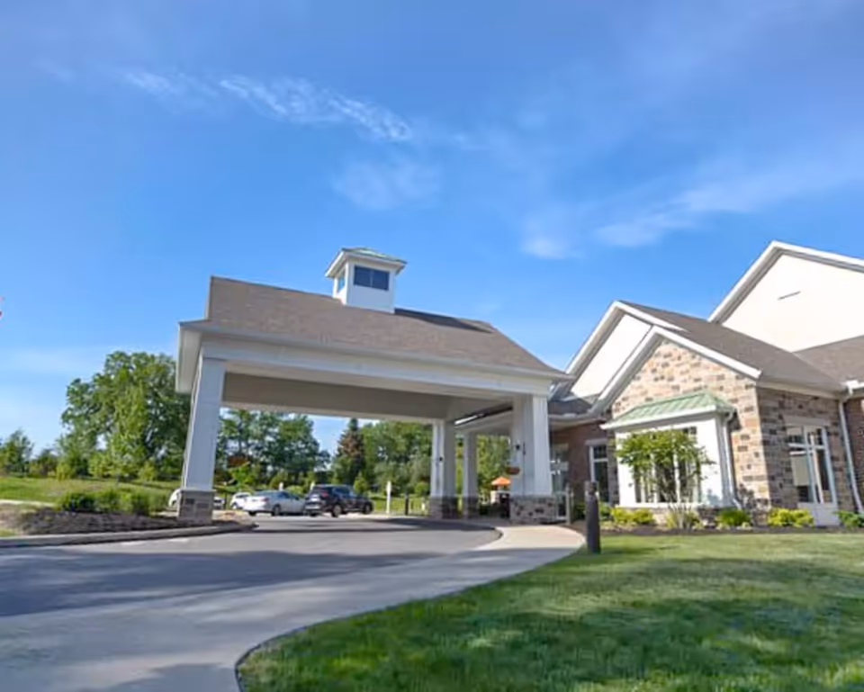 Vista Springs Ravinia Estate entrance with a covered drive and brick building on a sunny day.