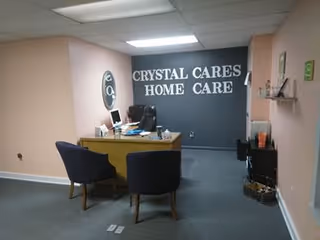 Reception area with a desk, two chairs, and a wall sign reading Crystal Cares Home Care.