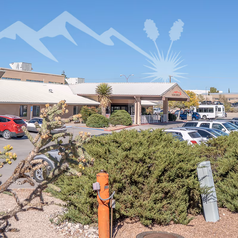 Exterior view of Paloma Springs Healthcare with entrance, parked cars, and desert landscaping.