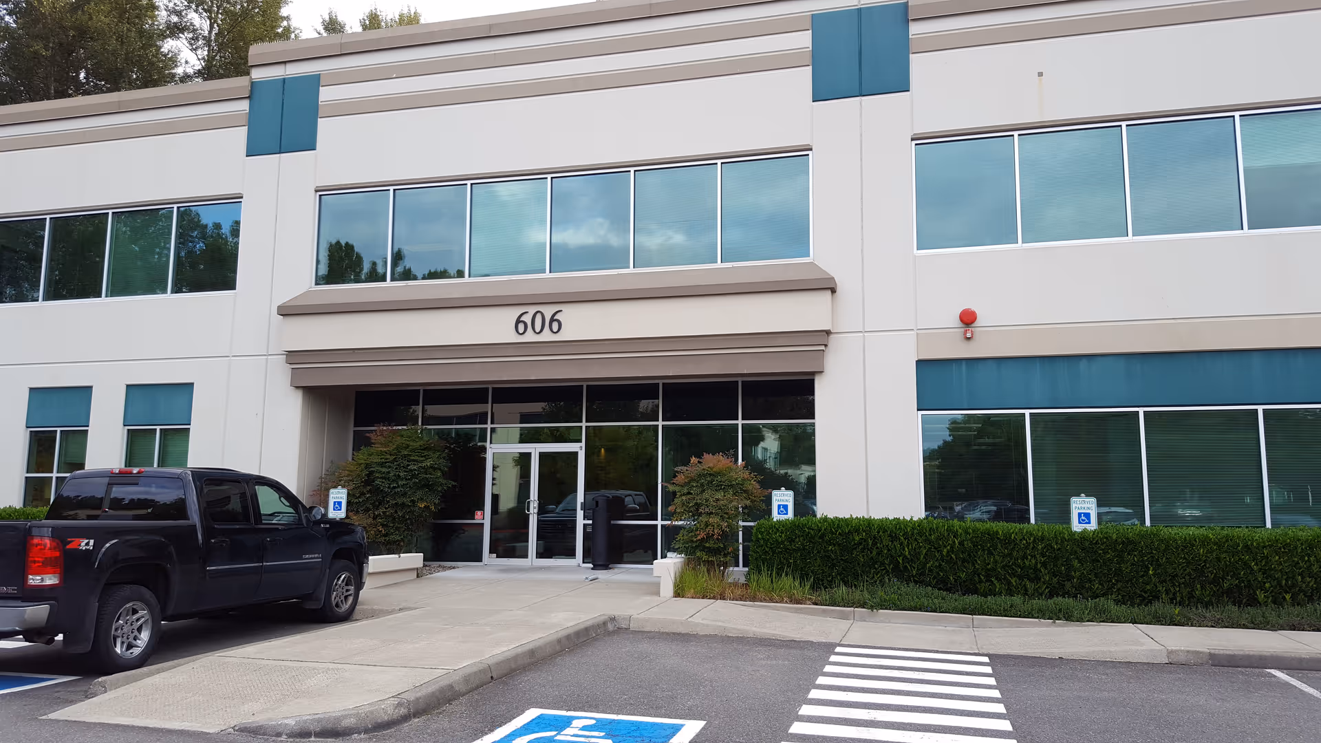 Front view of HarmonyCares Medical Group building with entrance, parking, and handicap signs.