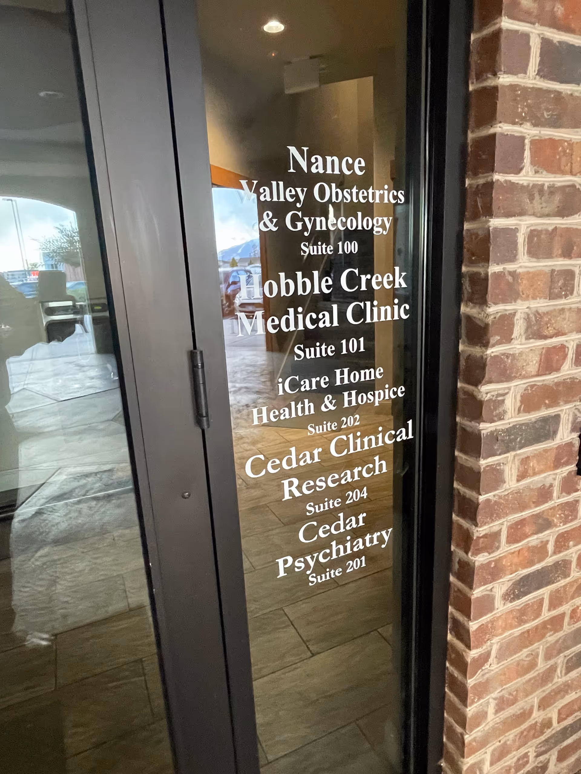 Glass entrance door with white text showing iCare Home Health and Hospice suites.