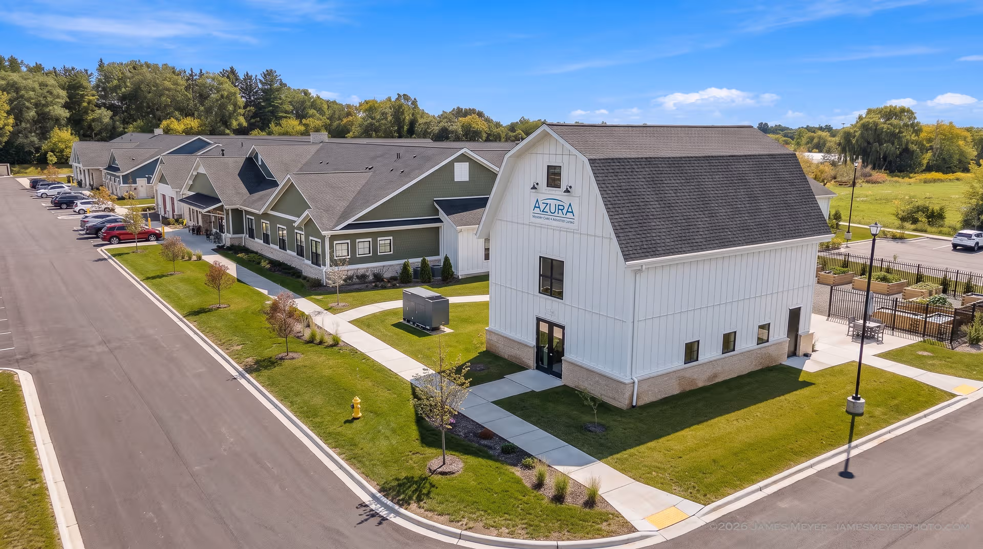 Aerial view of Azura Living campus with white building, green lawns, and road.