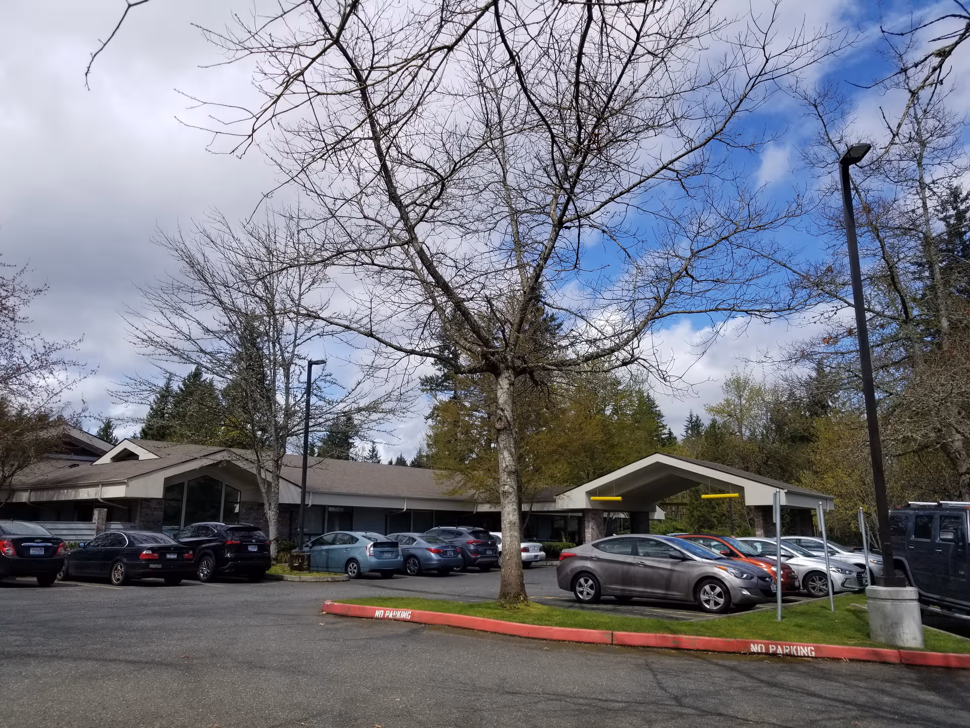 Exterior view of Providence Marianwood, showing a parking lot and building entrance under a covered drop-off.