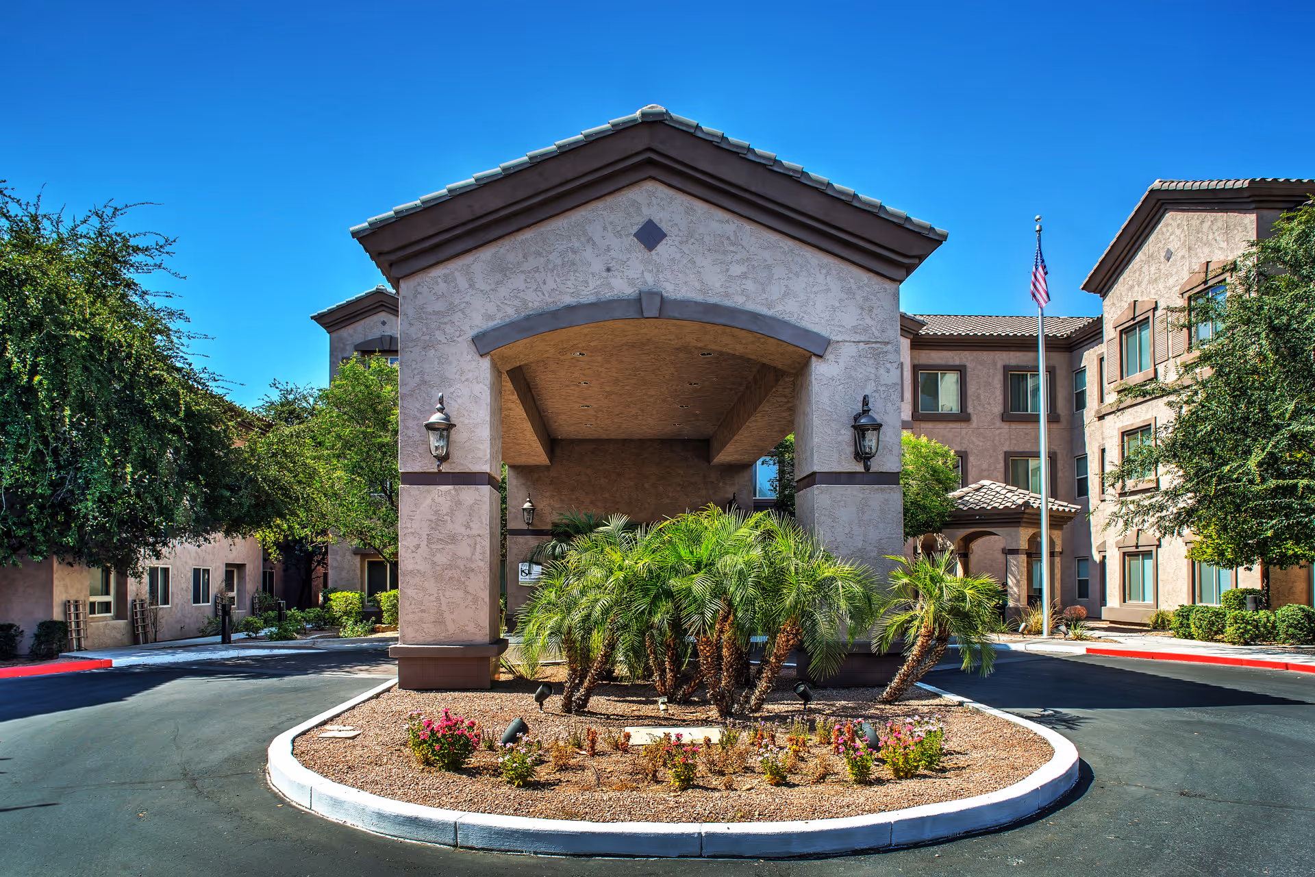 Front entrance of Ridge at the Stratford senior living community with a circular landscaped island.
