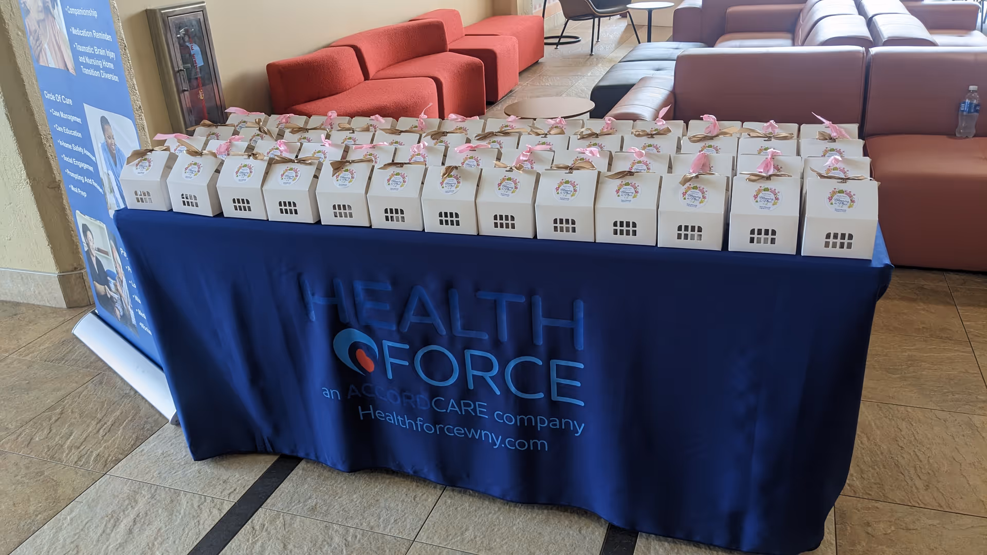 A table with a blue Health Force tablecloth displaying gift boxes in a lounge