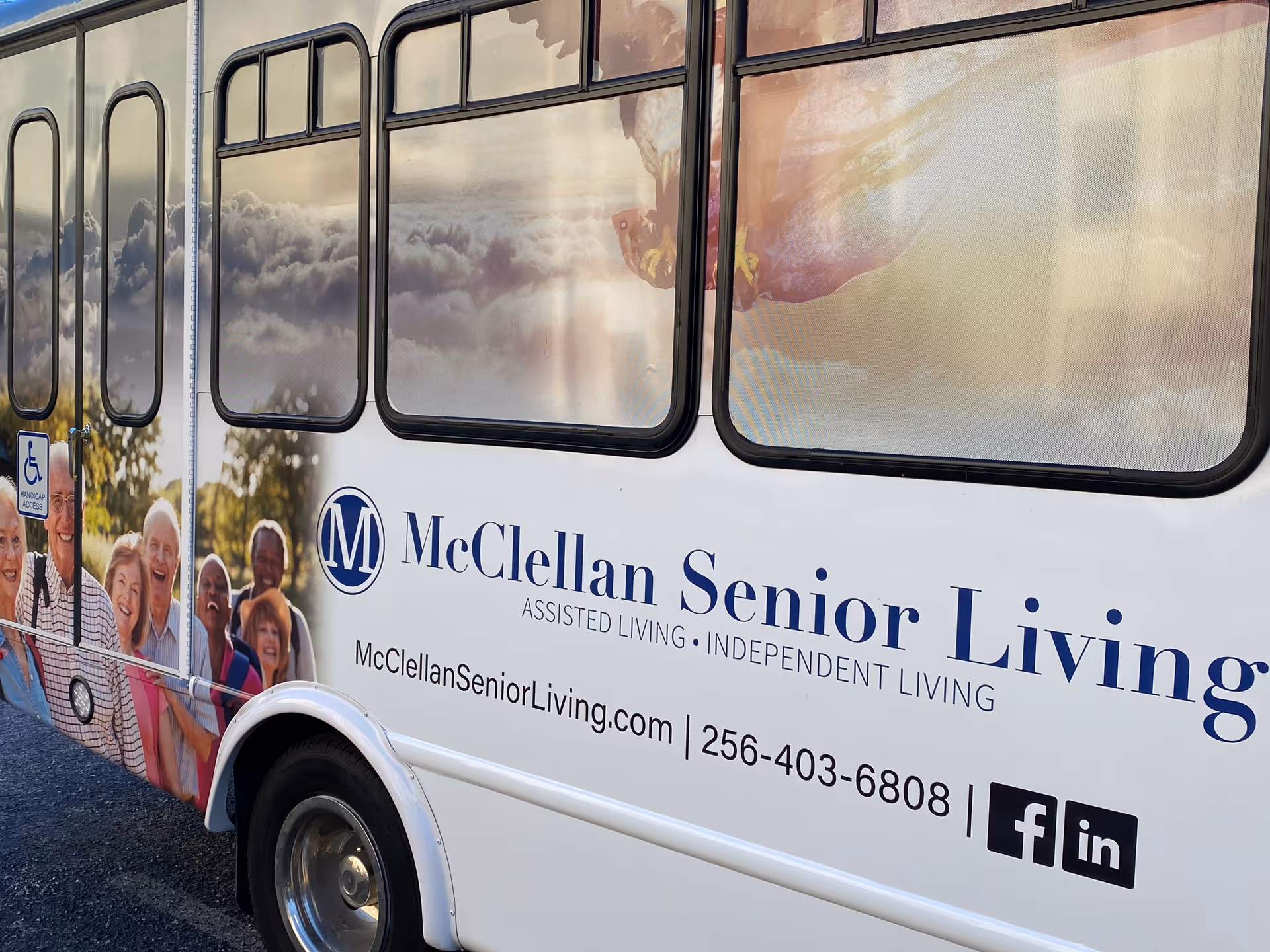 Side view of a McClellan Senior Living bus featuring seniors in the graphic