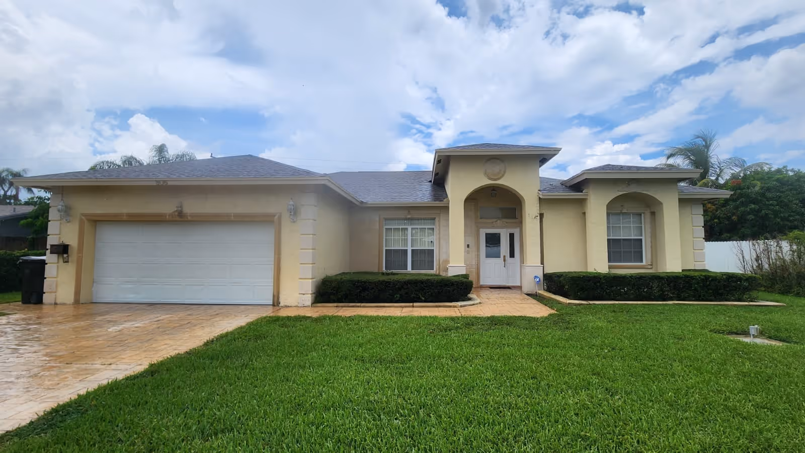 Exterior of Karing Hearts Residential Assisted Living building with beige facade and landscaped lawn.