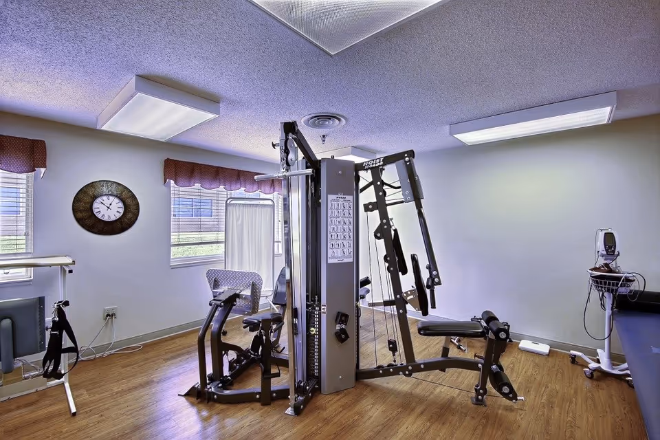 Interior gym in a senior living facility with weight machines and exercise equipment.