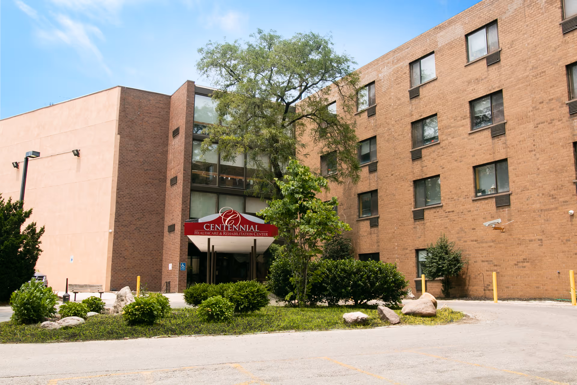 Exterior of Centennial Healthcare and Rehabilitation Center with entrance sign and landscaping.