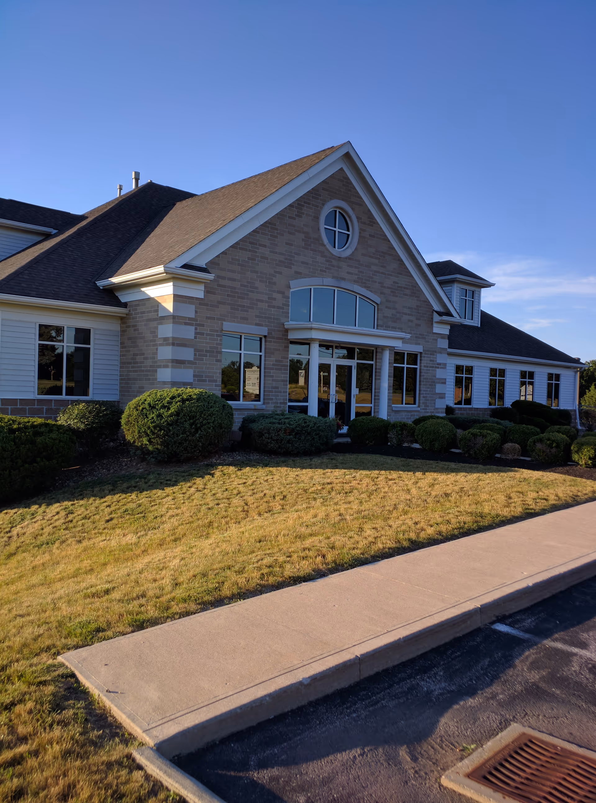 Exterior view of Evergreen Pain Management & Rehabilitation Center, a brick building with windows and landscaping.