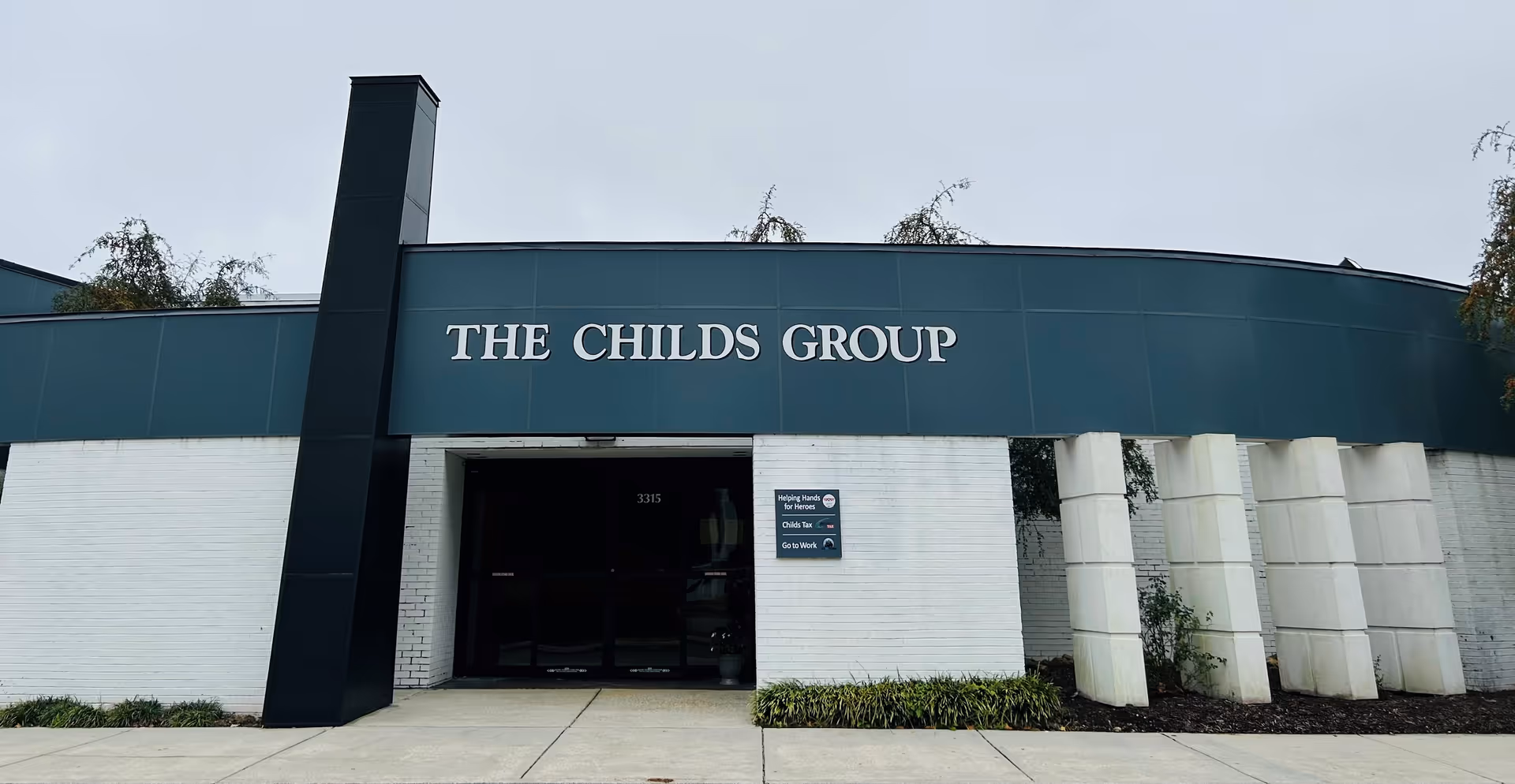 Front view of a building with teal facade and 'THE CHILD'S GROUP' sign.