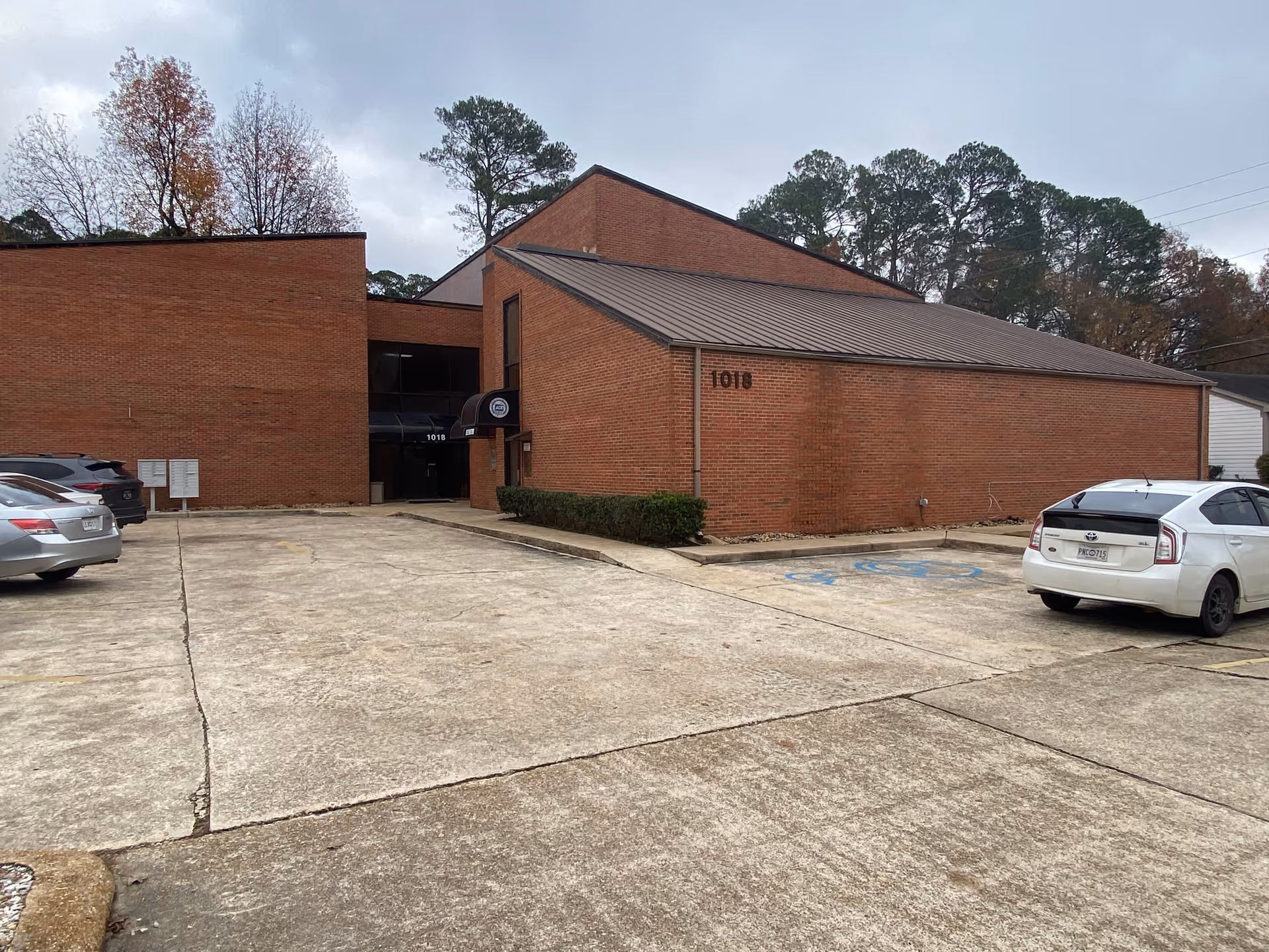 Brick senior living facility exterior with parking lot and front entrance.