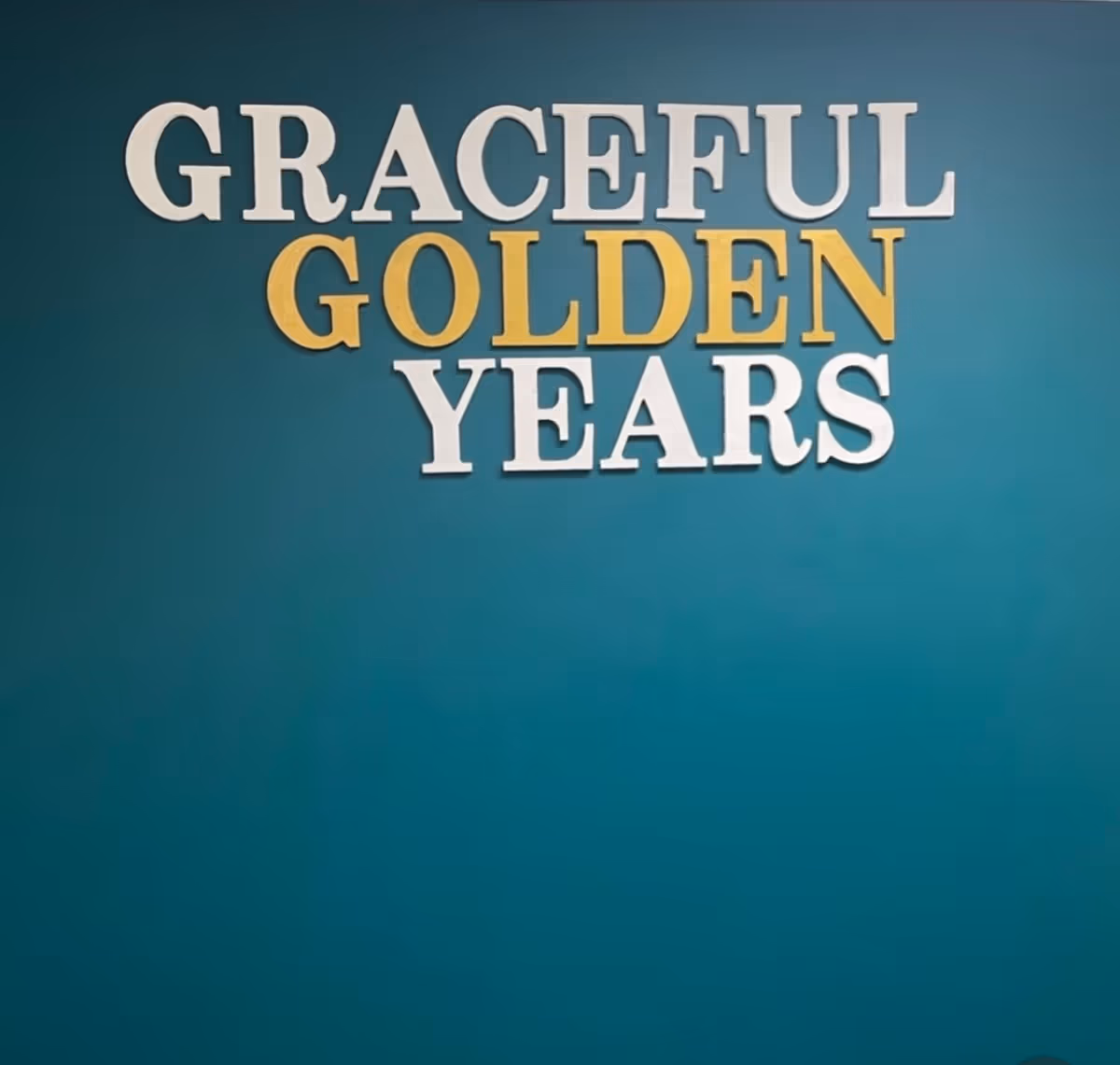 Teal wall with a large sign reading Graceful Golden Years.