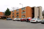 Exterior view of Elizabeth Wright Apartments, brick building with a parking lot in front.
