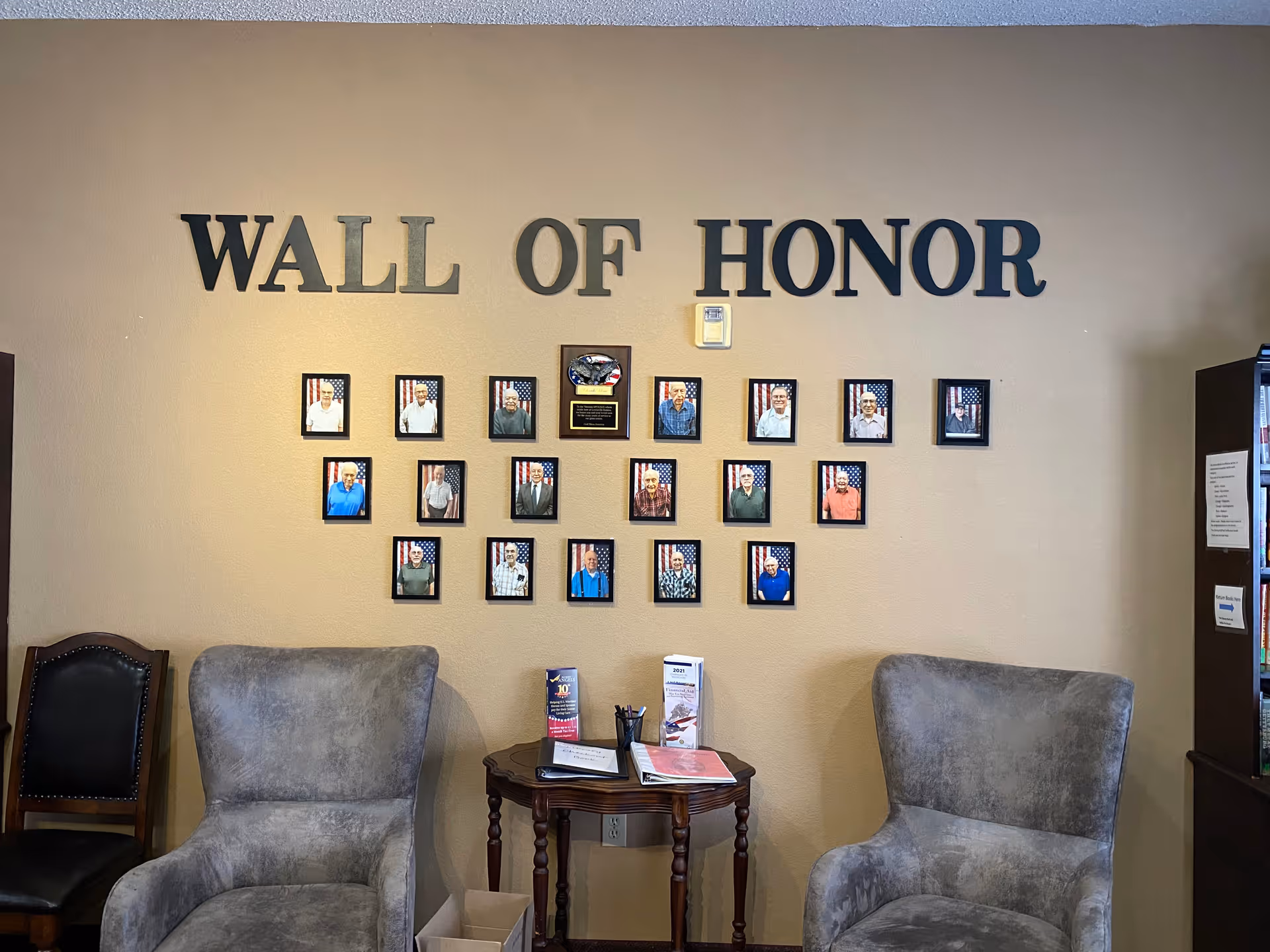 Lobby seating area with a Wall of Honor display of framed portraits.