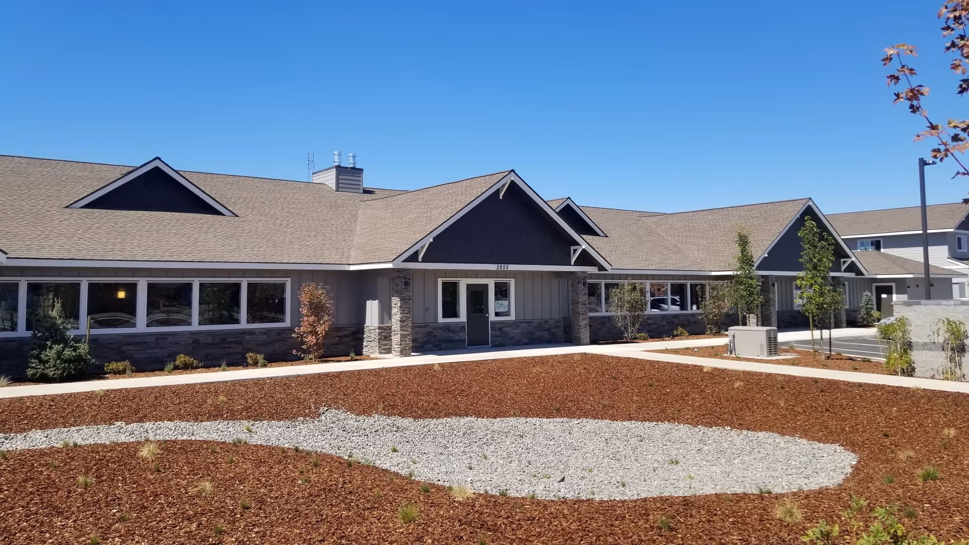 Front exterior of Juniper Canyon Living, a single-story facility with stone accents.