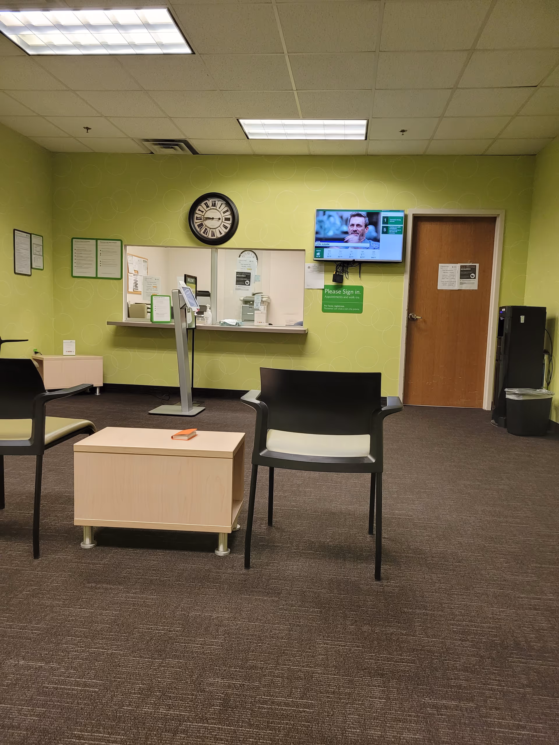 Lobby-style reception area with lime-green walls, seating, and a front desk.