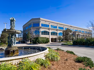 Exterior view of a multi-story senior living facility with a fountain
