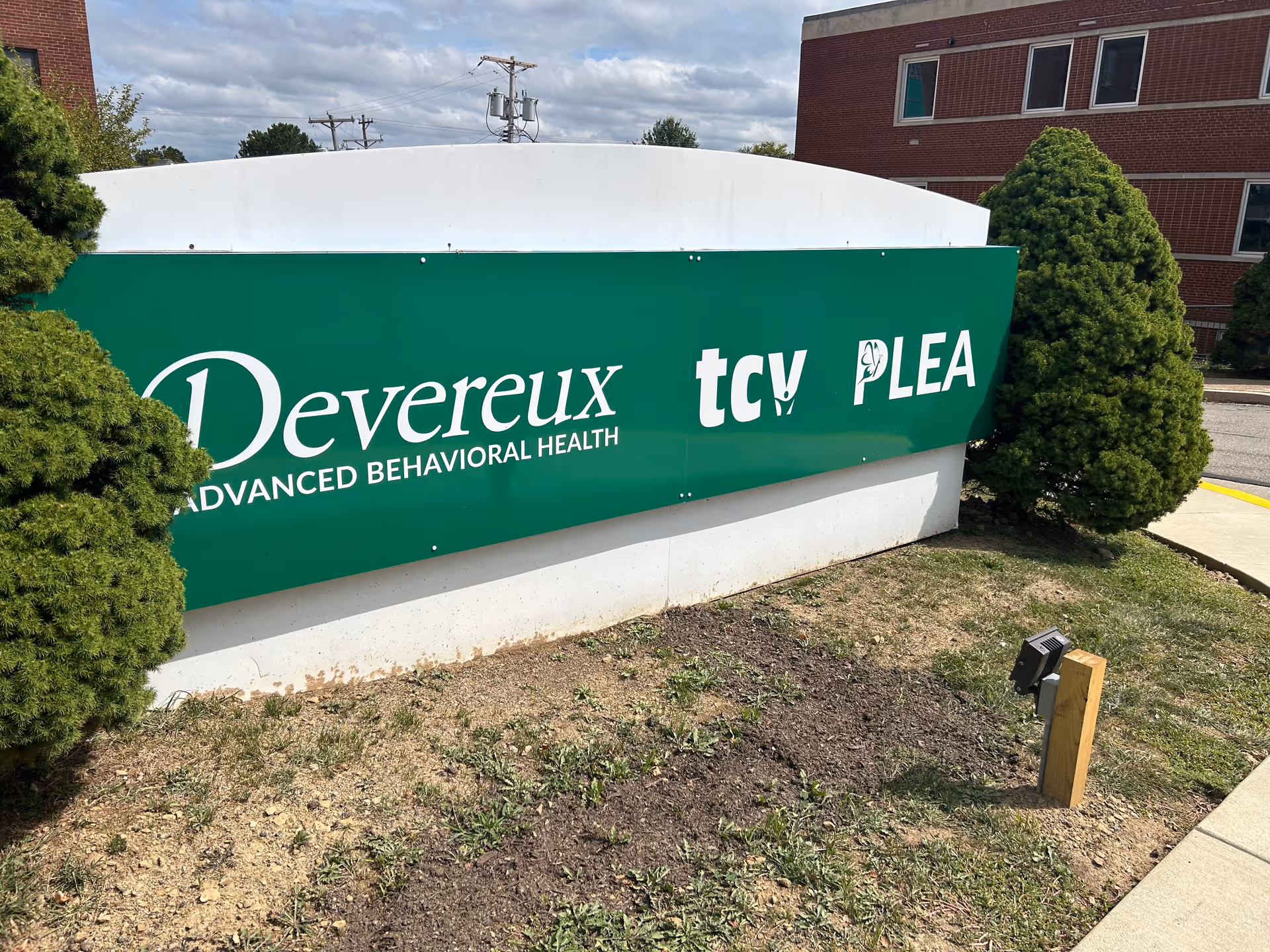 Green Devereux Advanced Behavioral Health sign on a concrete exterior wall.
