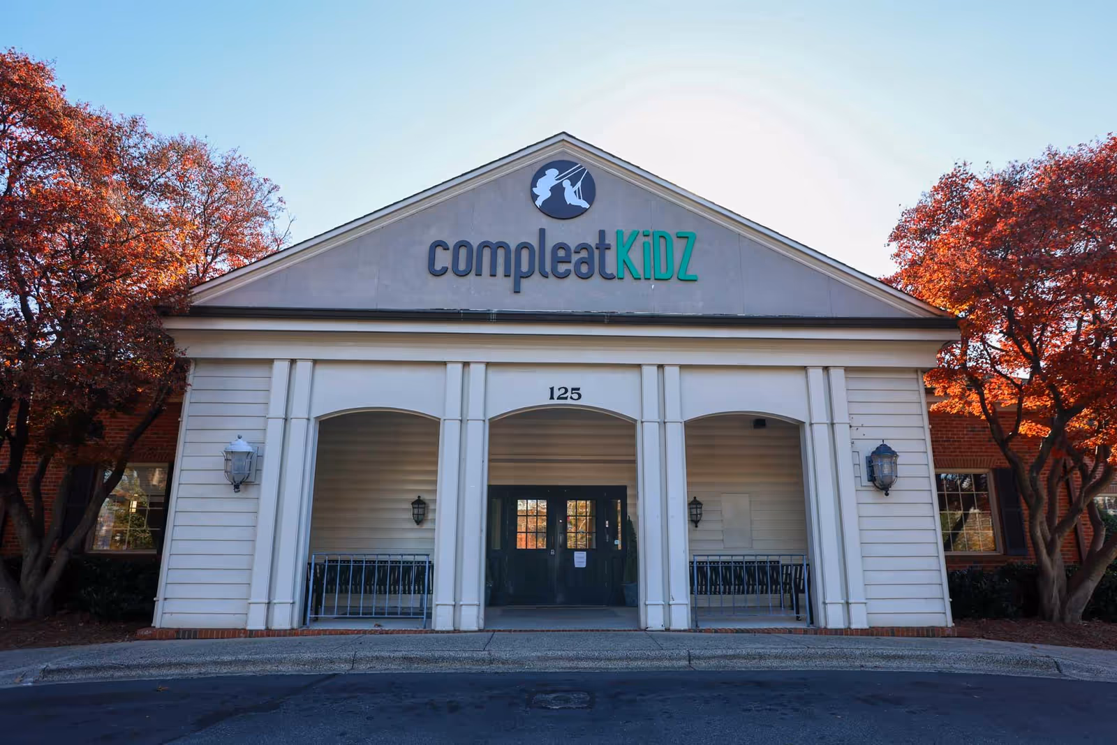 Front view of Compleat KiDZ ABA Pediatric Therapy entrance with trees on both sides.
