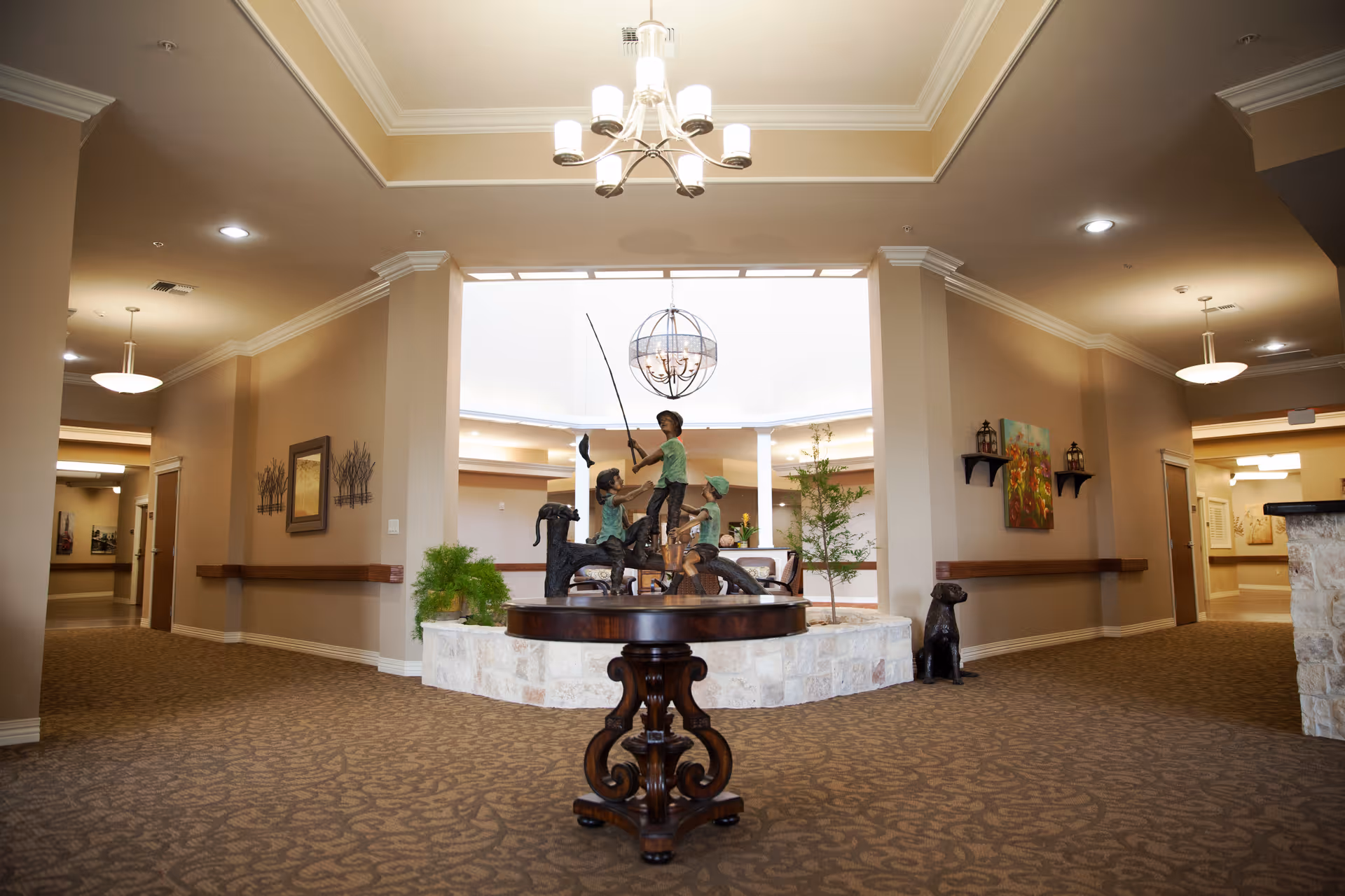 Spacious interior lobby of Hillside Heights Rehabilitation Suites featuring a central fountain sculpture.