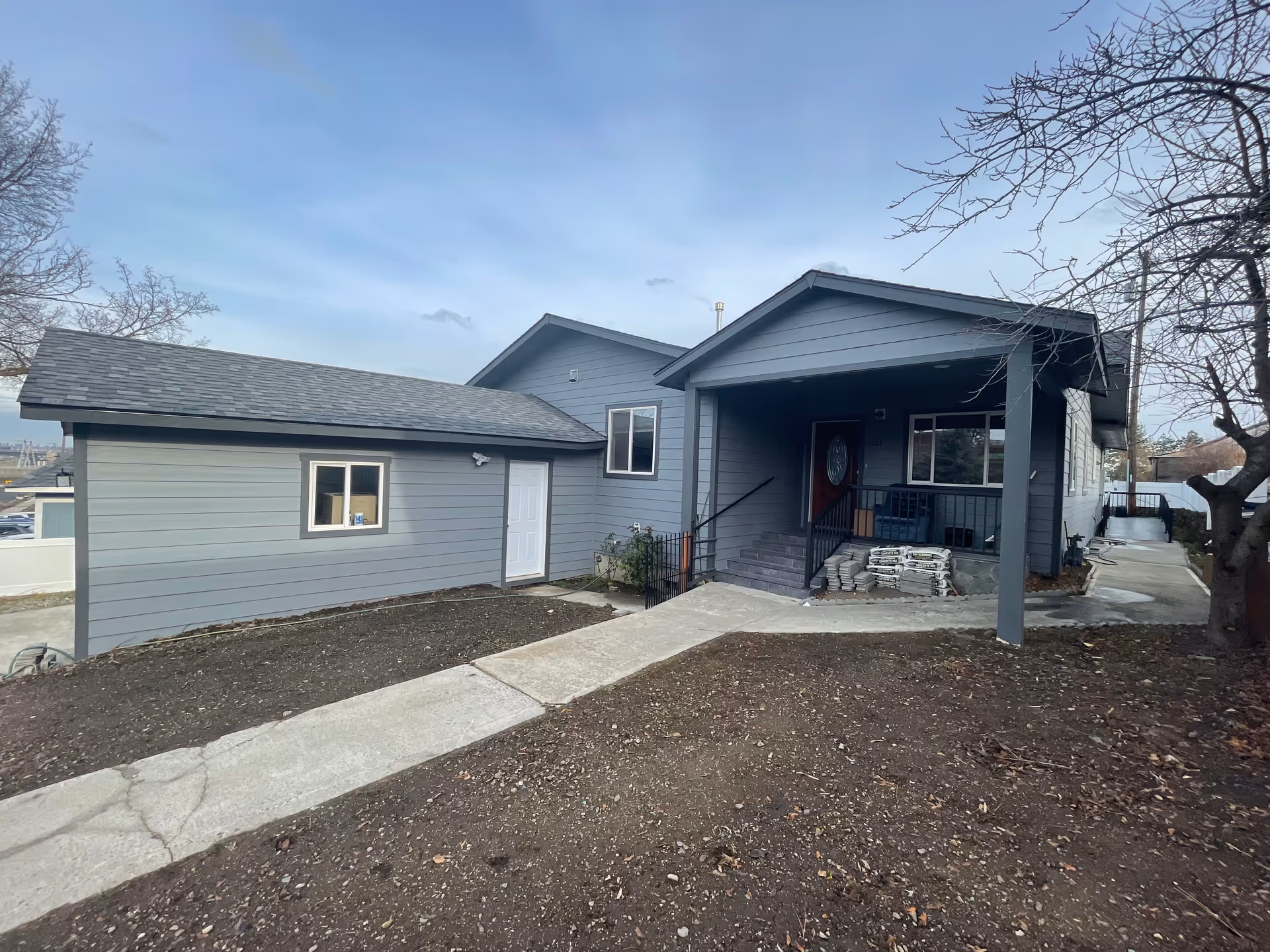 Blue-gray house-style facility with a covered front porch and walkway.