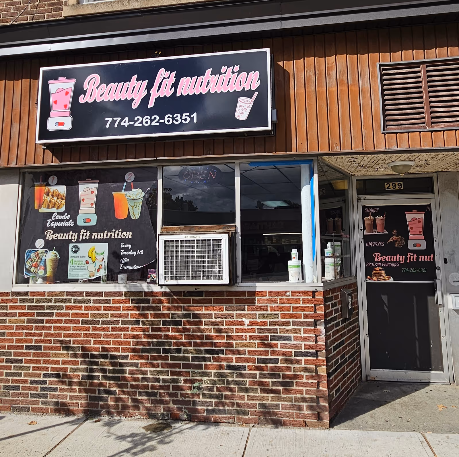 Exterior of Beauty fit nutrition storefront with brick wall and large sign