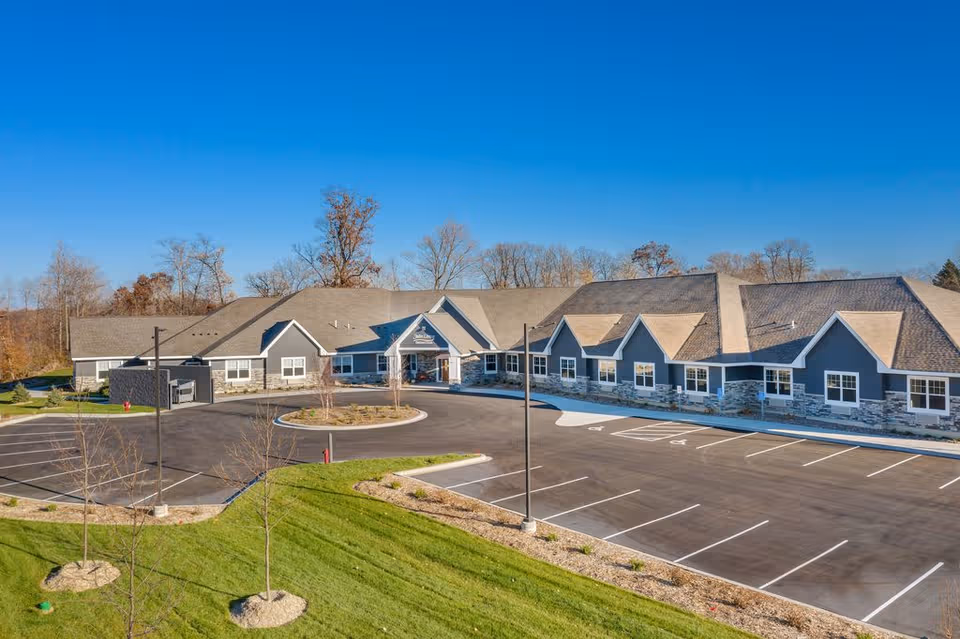 Exterior view of Suite Living Senior Care of Maple Grove with a parking lot.