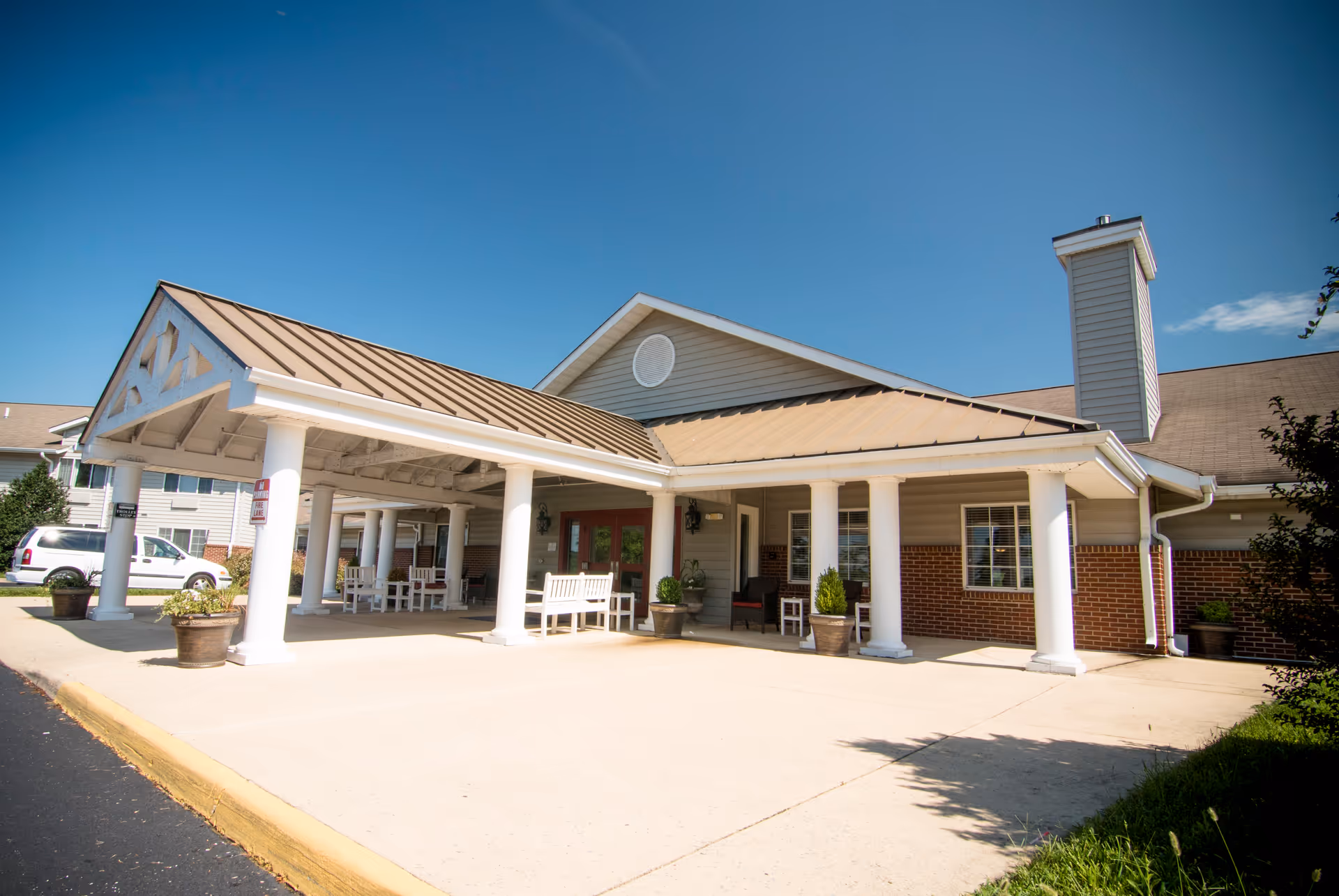 Brookdale Staunton facility entrance with covered drop-off, white columns, and brick facade.