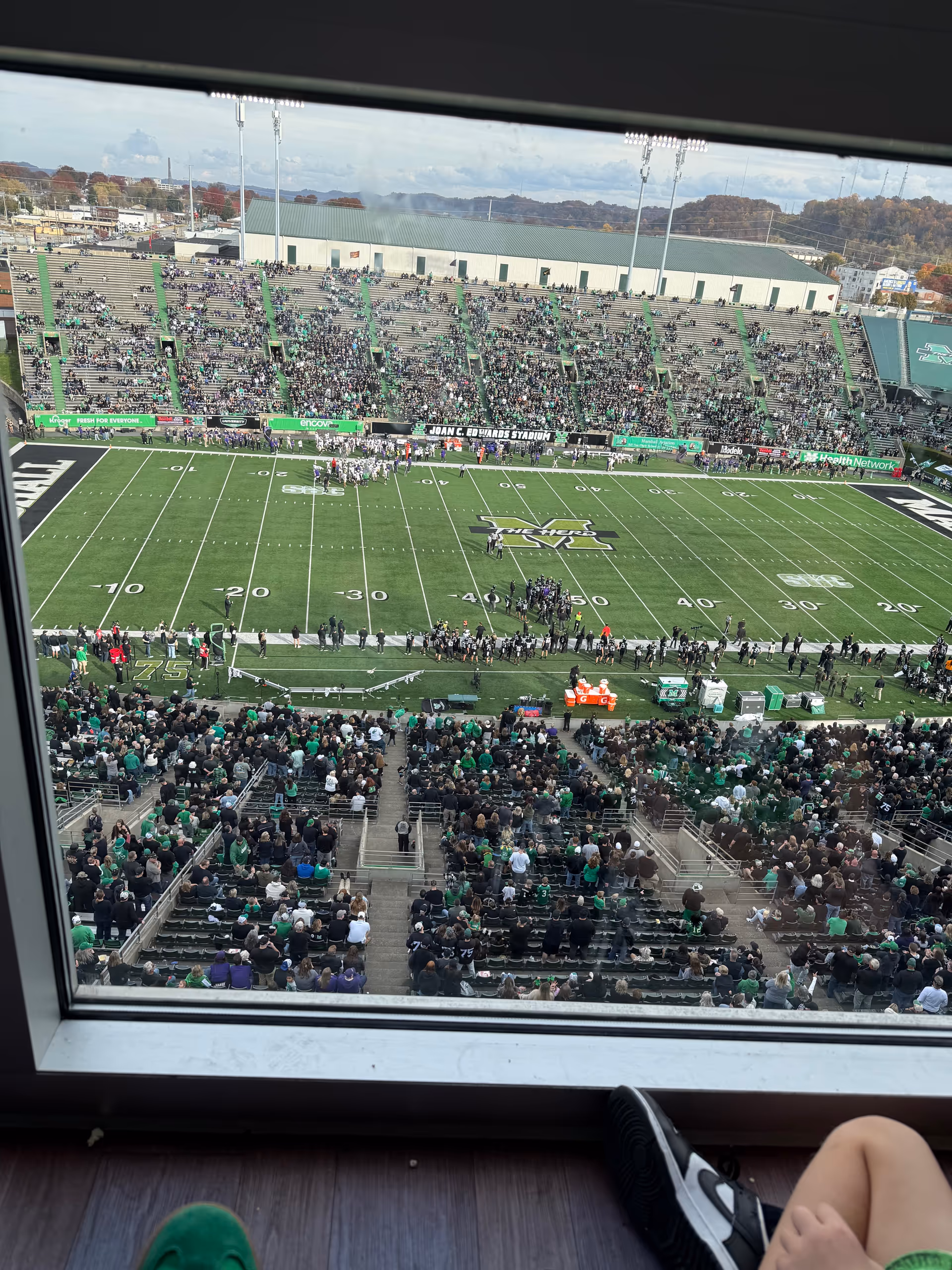 Crowded football stadium viewed from a window seat overlooking the field.