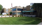 Exterior view of Allison Care Center with a green lawn and walkway.