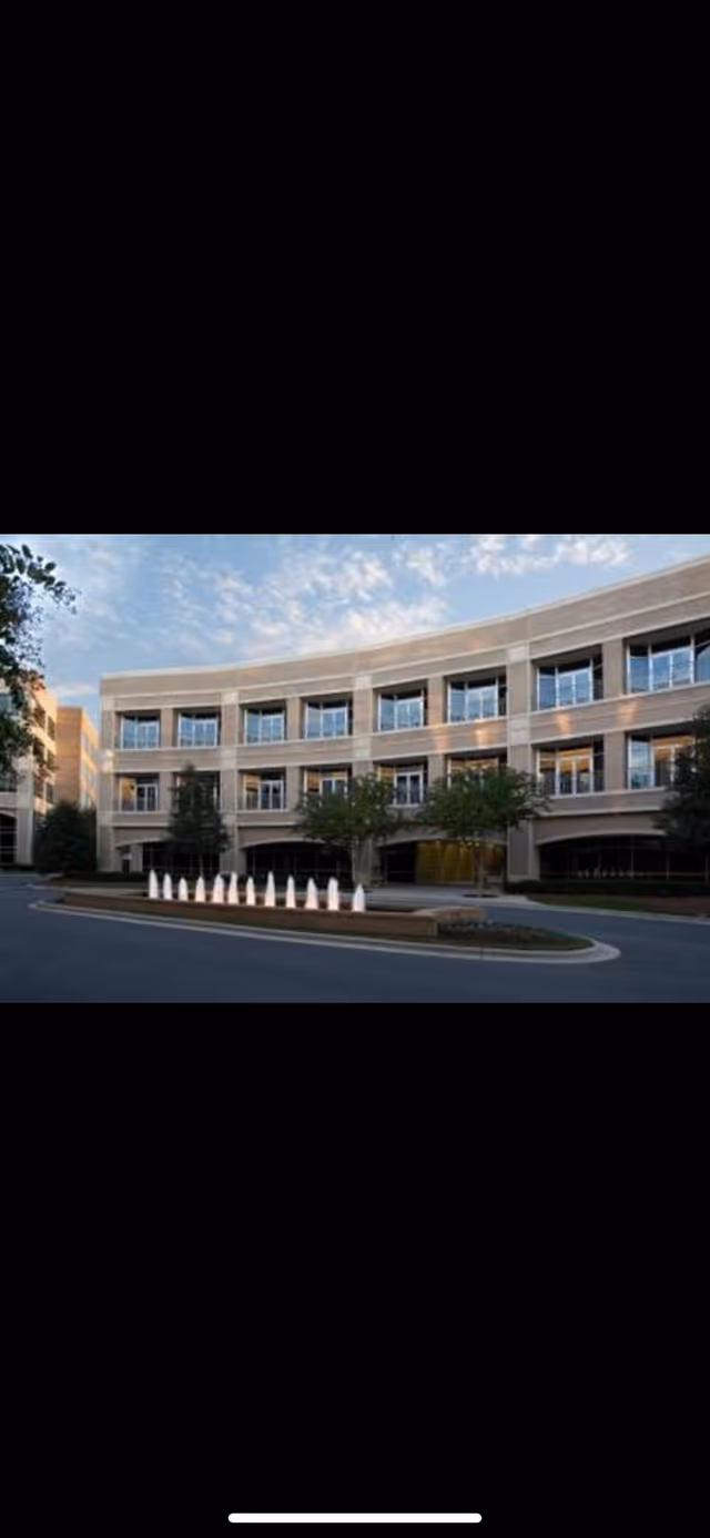 Exterior view of a curved senior living facility building with multiple windows.