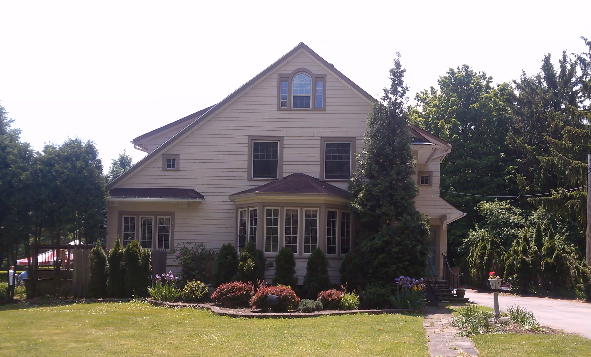 Exterior view of a beige two-story senior care facility with landscaped front yard.