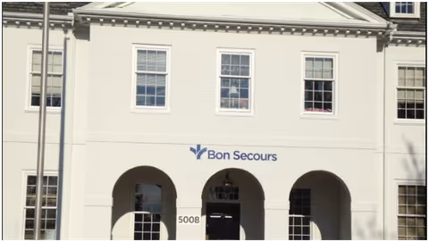 White building facade with arched entryways and Bon Secours sign.
