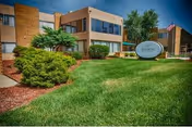 Front exterior view of Allison Care Center with manicured lawn and shrubs.