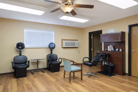 Salon area with chairs, hair dryers, and styling station inside a Brookdale Fort Smith facility.