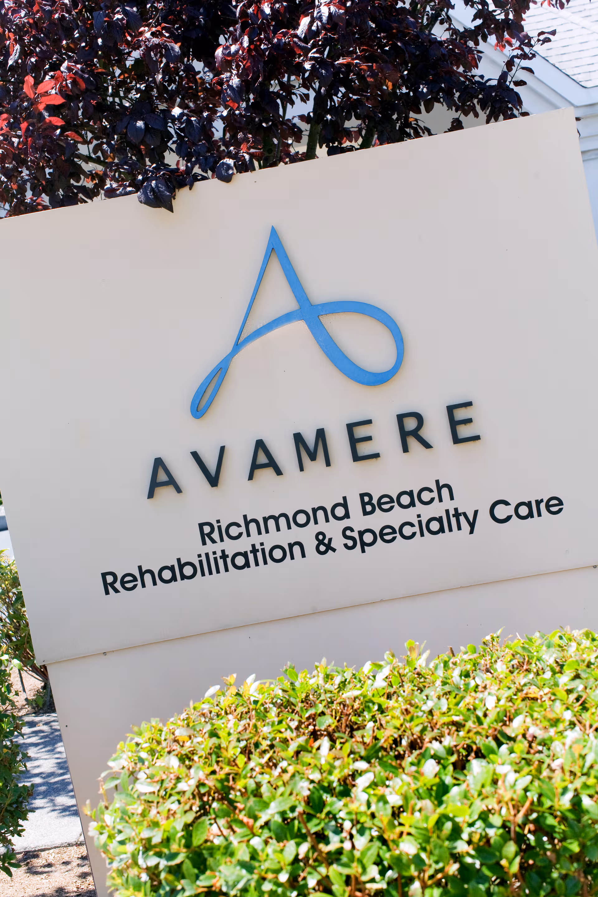 Large exterior sign reading Avamere Richmond Beach Rehabilitation and Specialty Care with greenery.