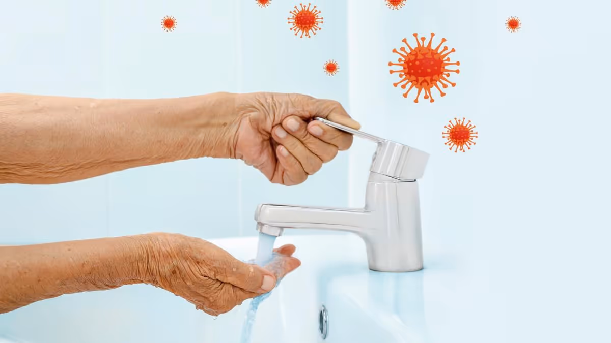 Close-up of hands washing under a faucet with virus icons in the background.