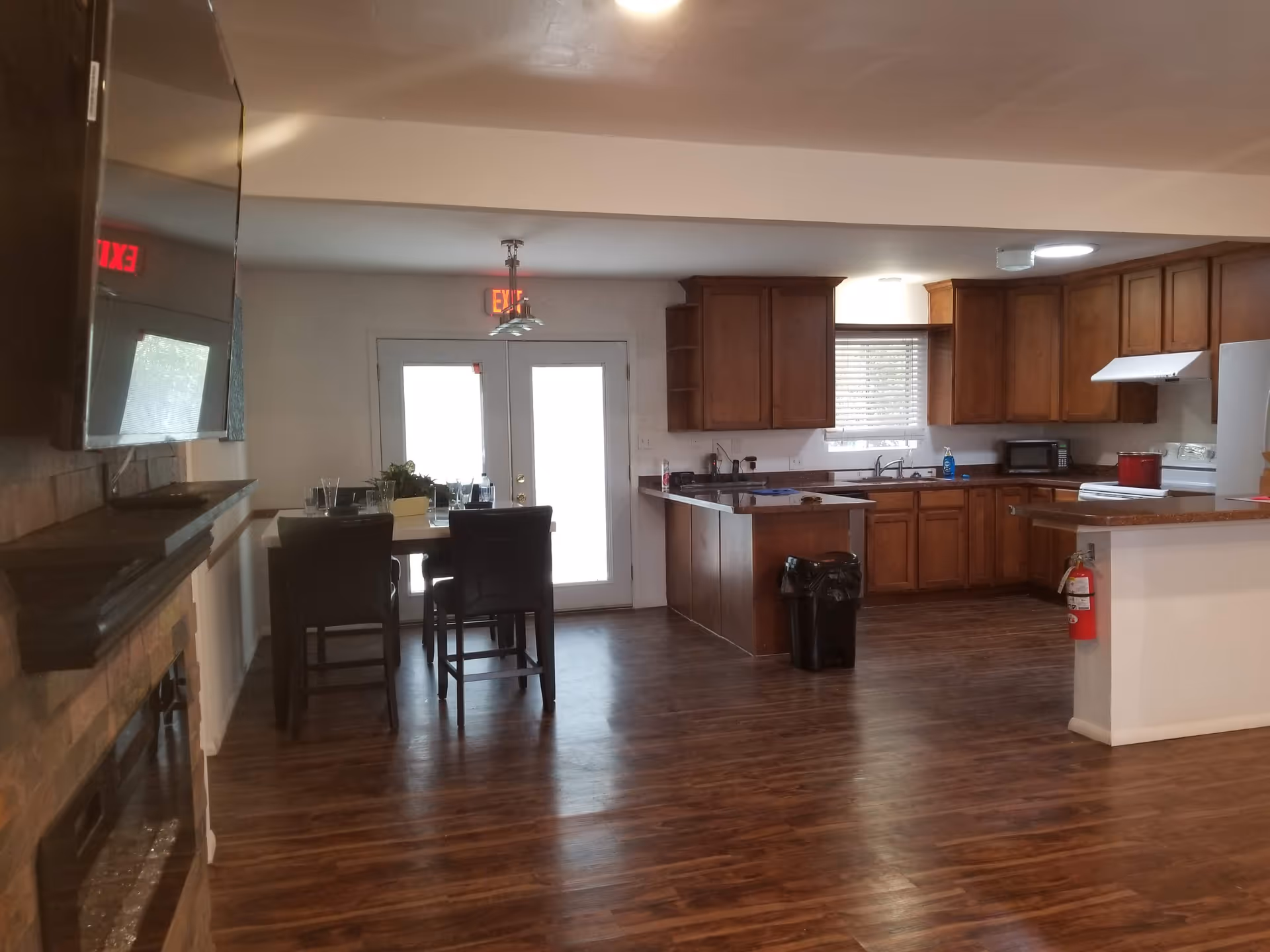 Open concept kitchen and dining area with wooden cabinets, island, and a back glass door.