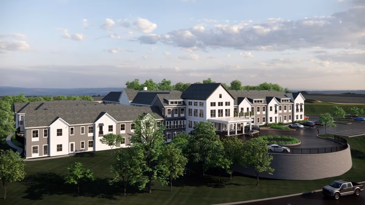 A large senior living campus with multiple buildings, greenery, and a curved driveway.