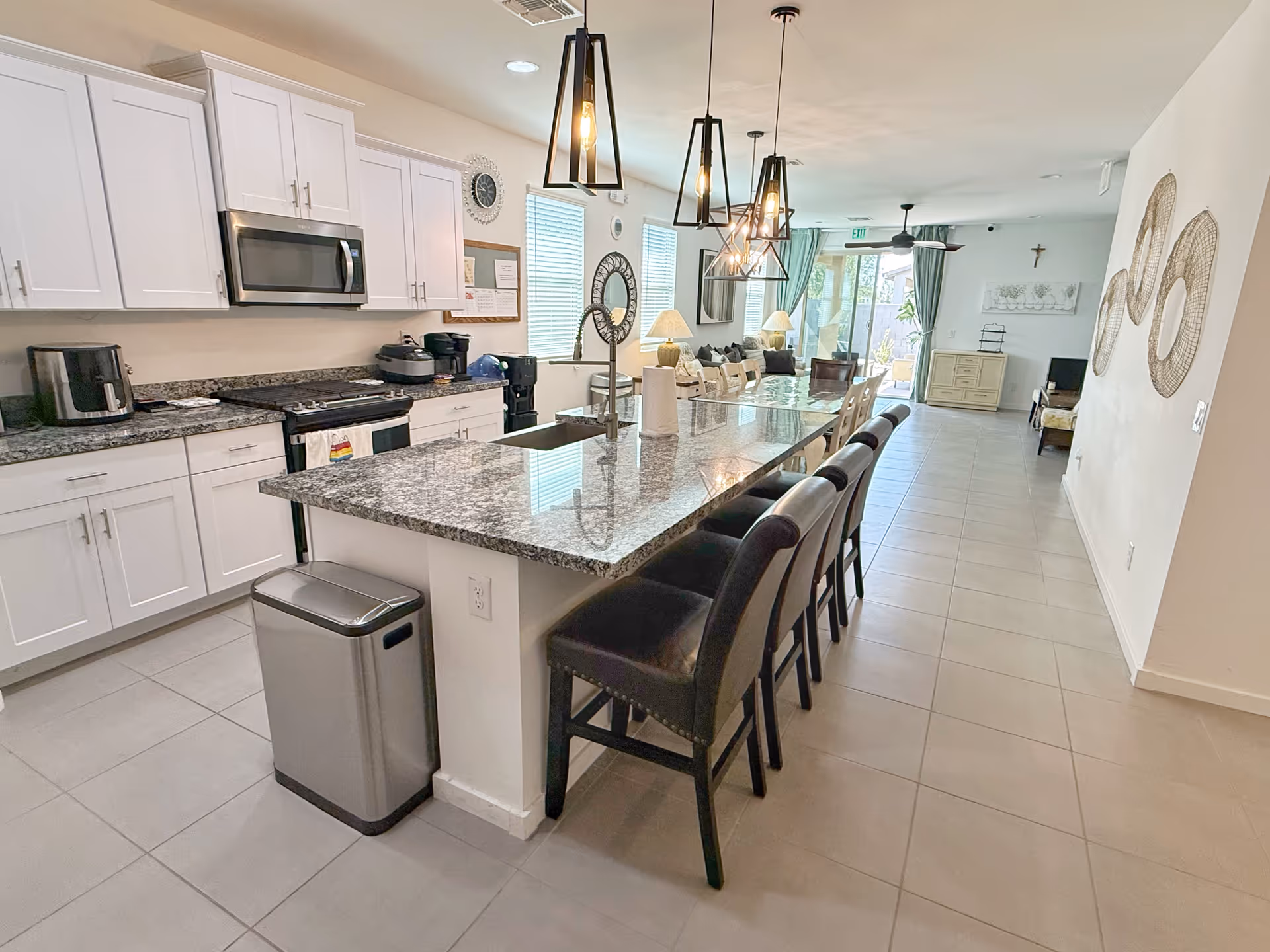 Open-concept kitchen with granite island and bar stools in a senior living facility.