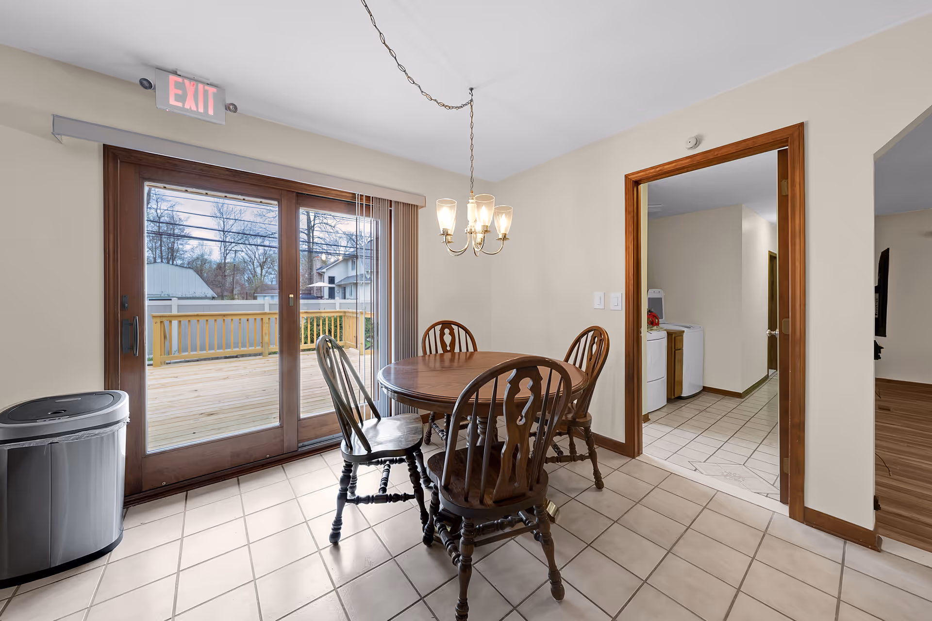 Interior dining room with a round wooden table and four chairs, sliding glass door to deck.