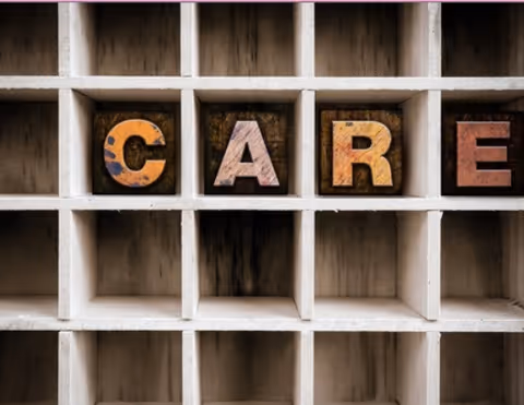 Close-up of cubby shelves with wooden letter blocks spelling CARE.