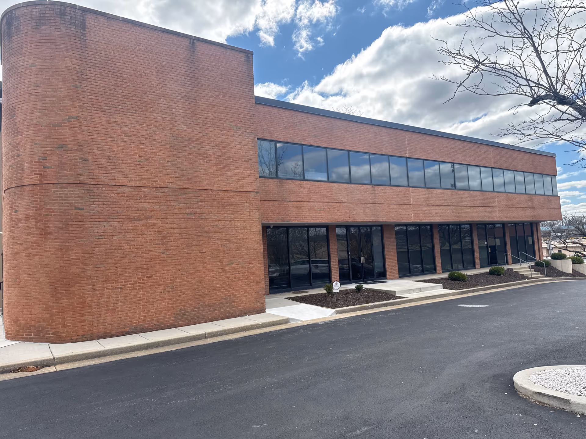 Brick exterior of a two-story facility with large windows and a glass entry.